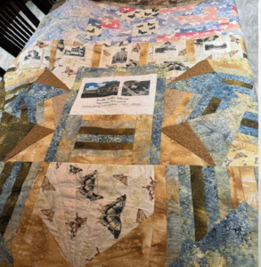 Quilt with images of Seymour libraries through the decades woven in it.